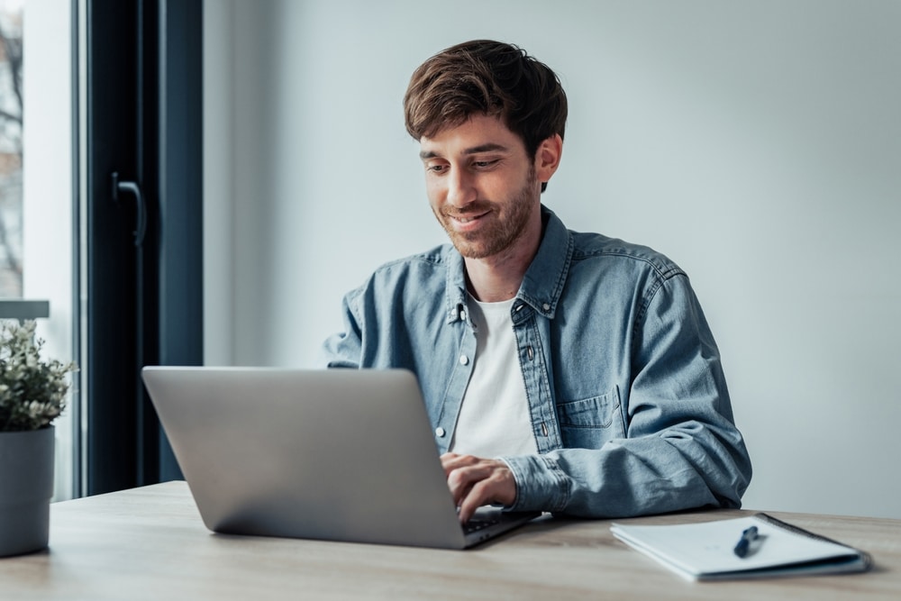 a man sitting at a desk using a laptop
